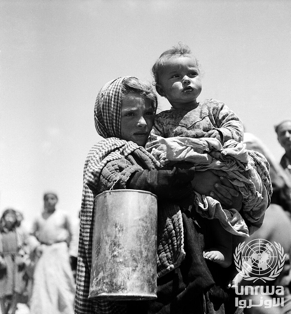 Palestinian refugee girl waiting for her daily ration of food and milk