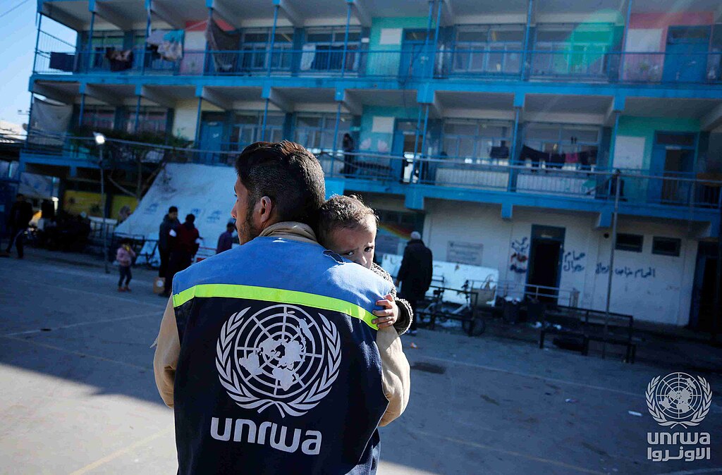 UNRWA worker carrying a child in Gaza